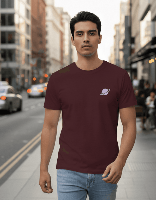 Male model walking confidently down an urban city street wearing a Maroon Supima cotton T-shirt by Lilak, featuring a small lavender planet graphic on the left chest